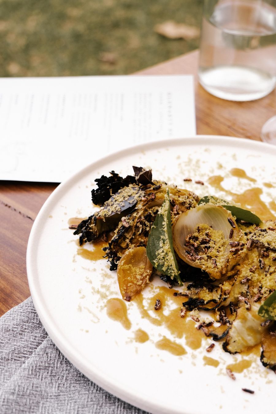 A plated dish of roasted vegetables and greens