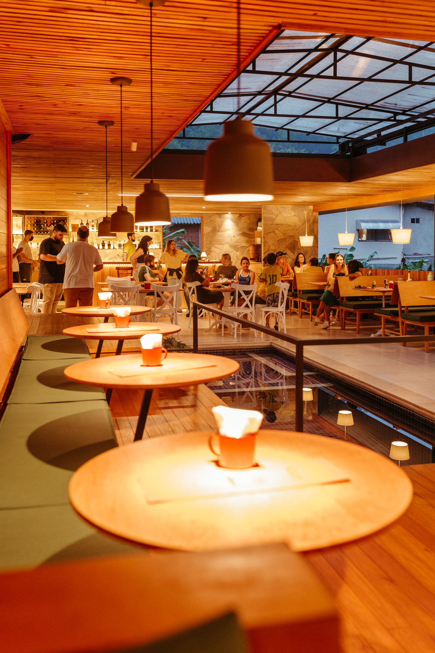 A warmly lit restaurant room with guests at tables